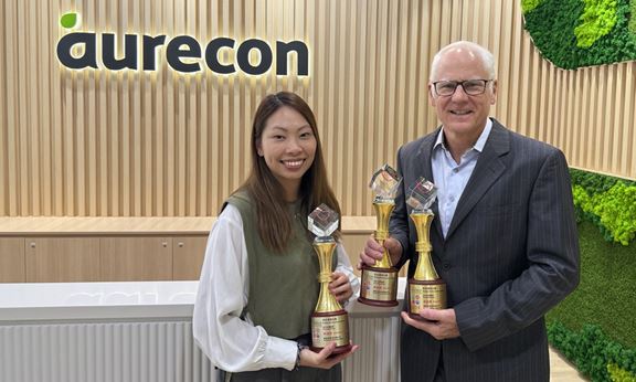 Stephane Asselin, Chief Executive for Asia, and Holly Leung, Health, Safety & Environment Manager, proudly hold the three trophies won in the past three years.