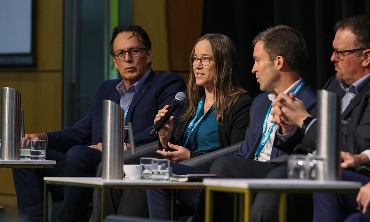 Amanda Pearce is captured speaking on a panel at a CollabX event.