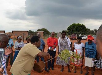 Food and Trees for Africa facilitator, Joe Matimba, explains how to loosen the soil around the tree before planting it
