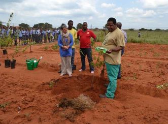 Food and Trees for Africa facilitator, Joe Matimba, explains how to implement a drip system by using a two litre plastic container to ensure that the tree gets enough water