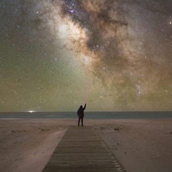 Graphic image of a person waving at the sky at night