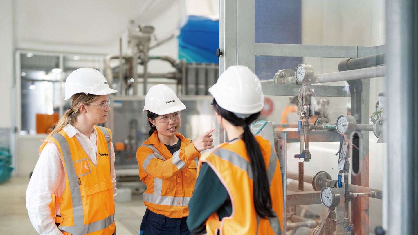 Help us shape the future of water in Australia and Aotearoa. Three females wearing PPE having a discussion at a water treatment facility.