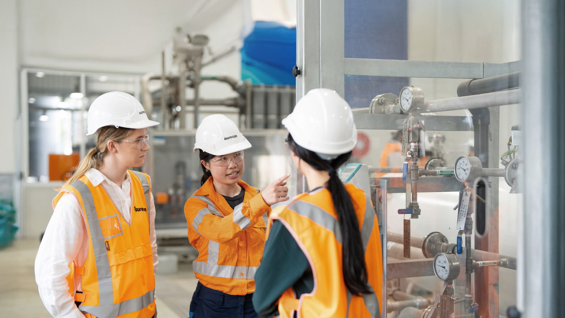 Help us shape the future of water in Australia and Aotearoa. Three females wearing PPE having a discussion at a water treatment facility.