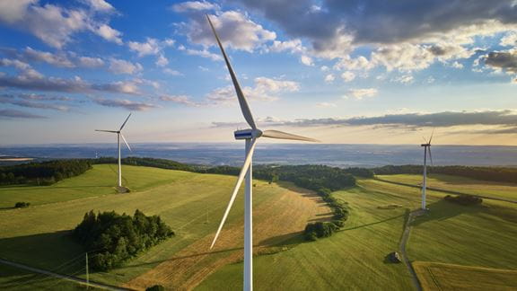 The view of the wind farm at sunset emphasises the scale of renewable energy infrastructure.
