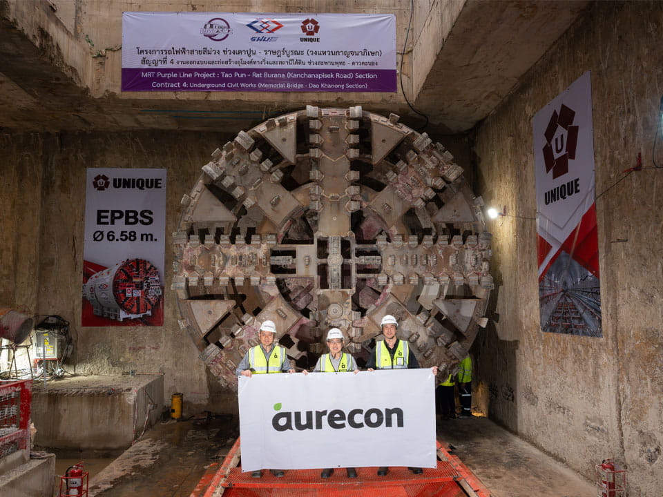 MRT Purple Line South extension in Bangkok. Aurecon team poses in front of tunnel boring machine.