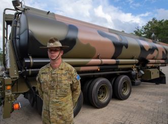 An Australian Defence employee standing in front of a vehicle that transports Defence fuel. Image courtesy of Australian Government Department of Defence.
