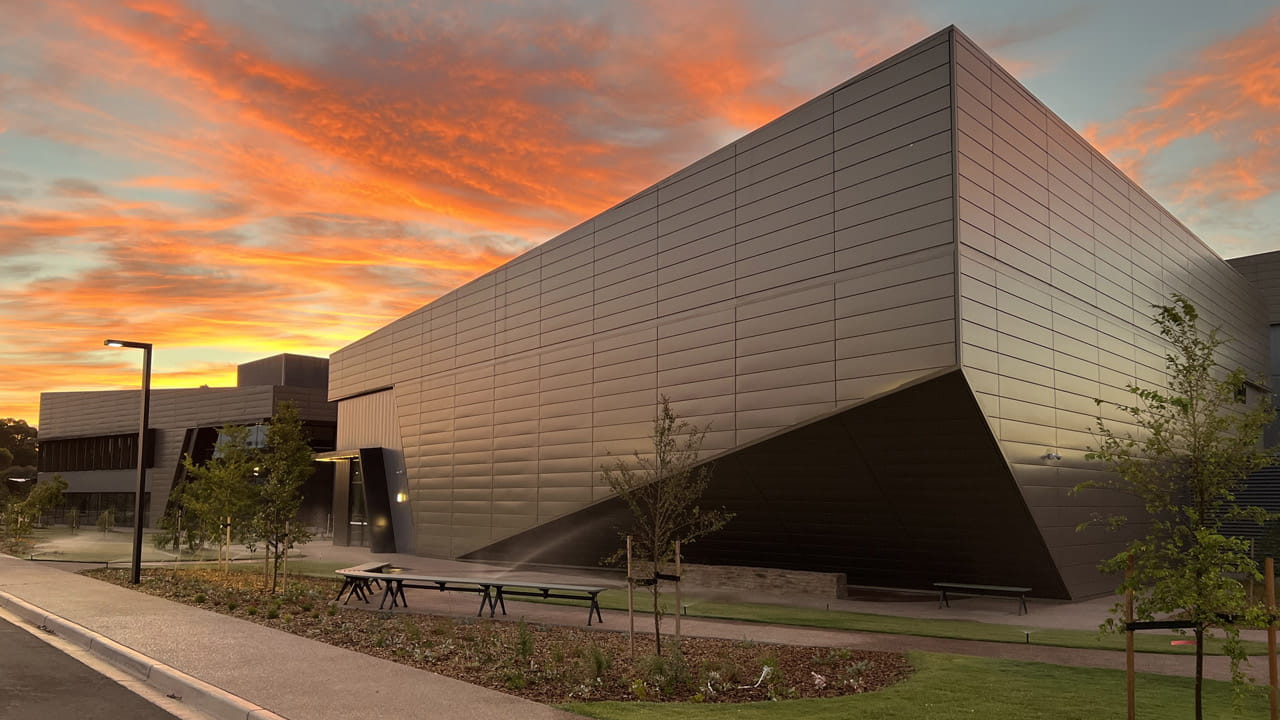 The school features a landscaped plaza at the ground level with a connection to outdoor learning opportunities and recreation spaces.