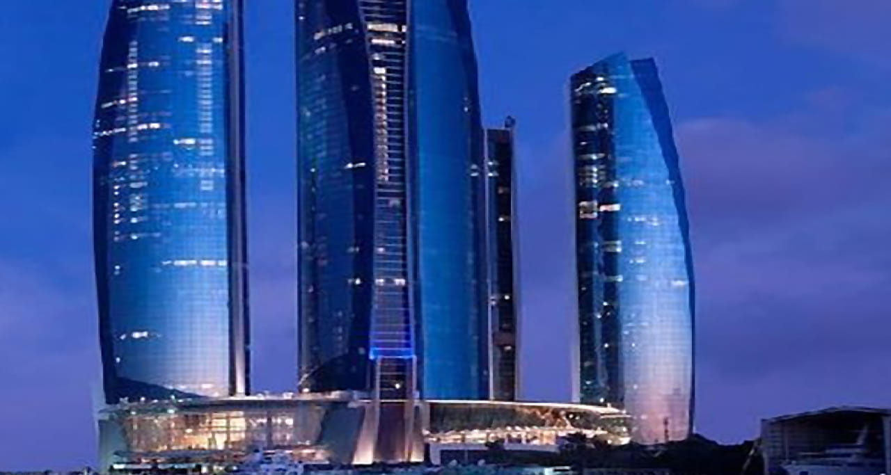 Etihad Towers all lit up at night.