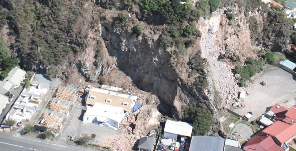 Houses built on the side of a cliff, impacted by falling rocks at Port Hills, Christchurch. 
