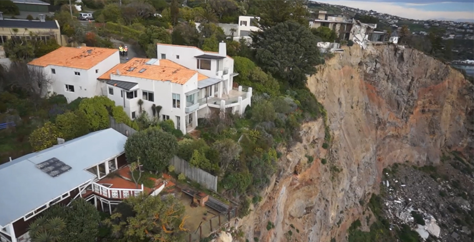 View of some of the houses located on the edge of a cliff, that were flagged as part of the Port Hills Red Zone Property Management project. 