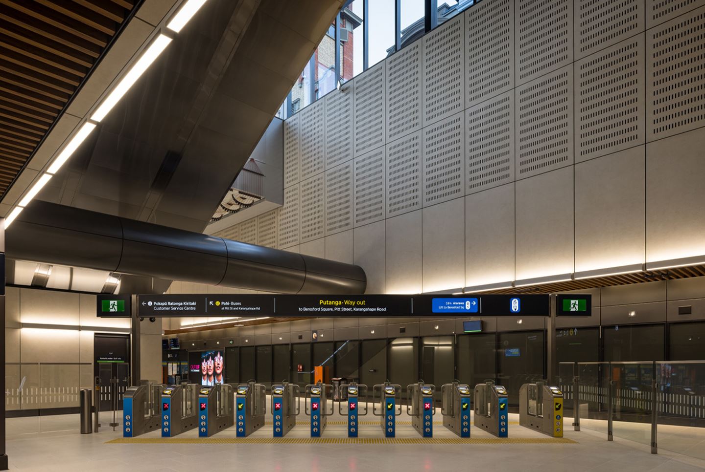 Modern automated ticket barriers, distinctive acoustic panelling and architectural lighting of the newly completed Karanga-a-Hape Station on Auckland's CRL in New Zealand.