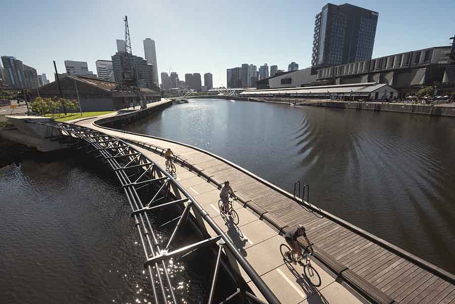 Cyclists on the Jim Stynes Bridge crossing the Yarra River. Image courtesy of John Gollings.