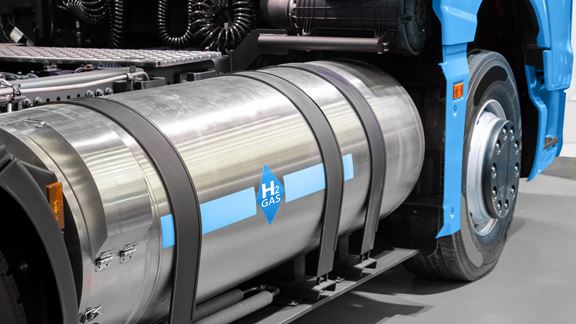 Hydrogen fuel storage cylinder labelled with an H₂ Gas diamond emblem mounted on the chassis of a heavy-duty commercial truck.