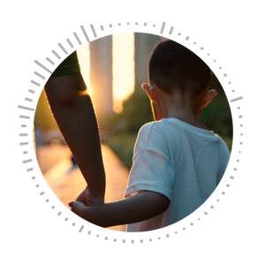 Young boy holding parent's hand